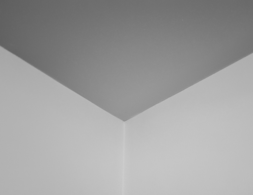 A black and white photo of a ceiling with no cornice.