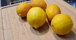An assortment of lemons on the official Bradism Raised Cutting Board for Tall People